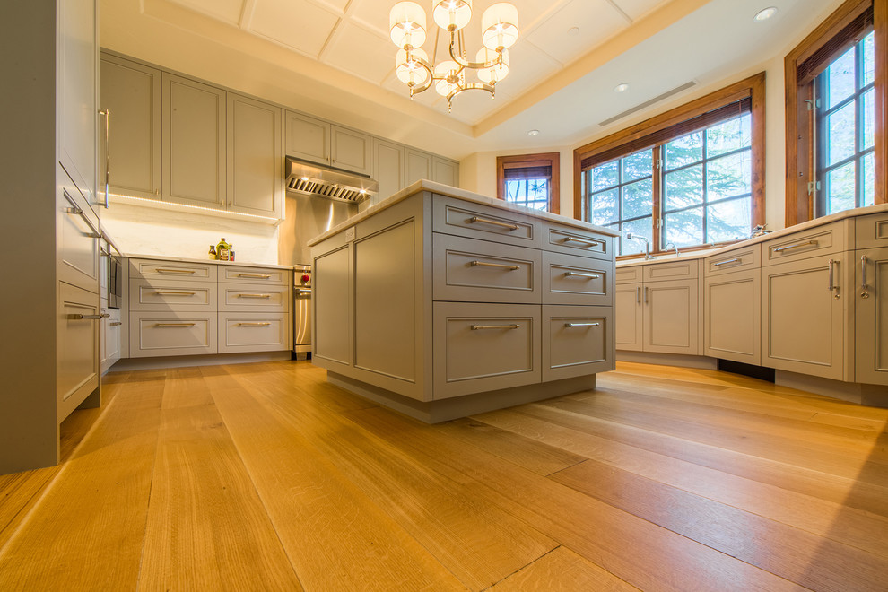 Photo of a large traditional grey and brown u-shaped kitchen pantry in Denver with a submerged sink, beaded cabinets, grey cabinets, marble worktops, beige splashback, marble splashback, integrated appliances, medium hardwood flooring, an island, brown floors, multicoloured worktops and a coffered ceiling.