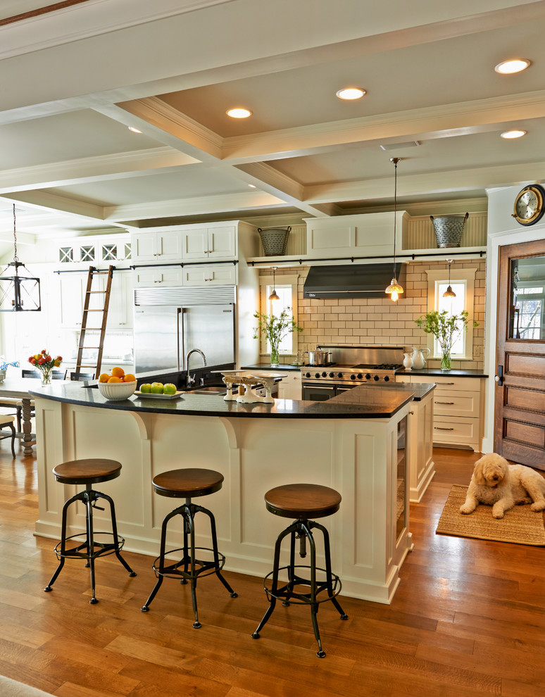 Design ideas for a traditional kitchen/diner in Milwaukee with shaker cabinets, white cabinets, metro tiled splashback, stainless steel appliances and medium hardwood flooring.