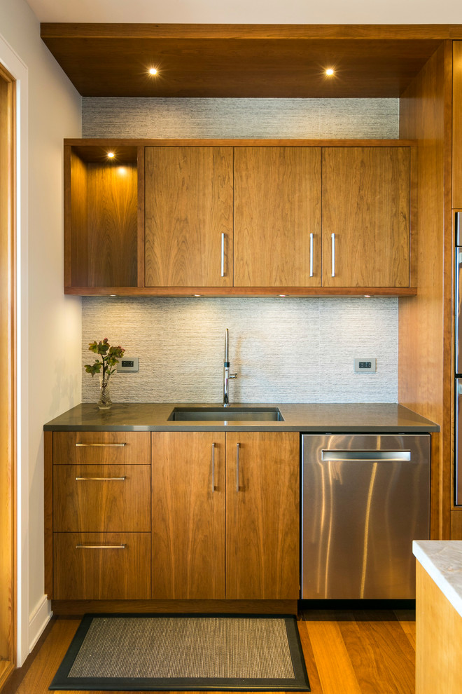 Mid-sized minimalist l-shaped medium tone wood floor open concept kitchen photo in Vancouver with an undermount sink, flat-panel cabinets, medium tone wood cabinets, marble countertops, beige backsplash, matchstick tile backsplash, stainless steel appliances and an island