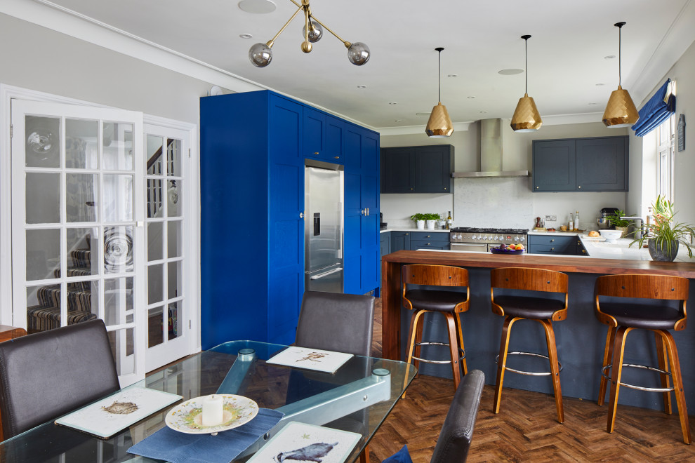 Esempio di una cucina eclettica di medie dimensioni con ante blu, top in quarzite, elettrodomestici in acciaio inossidabile e penisola
