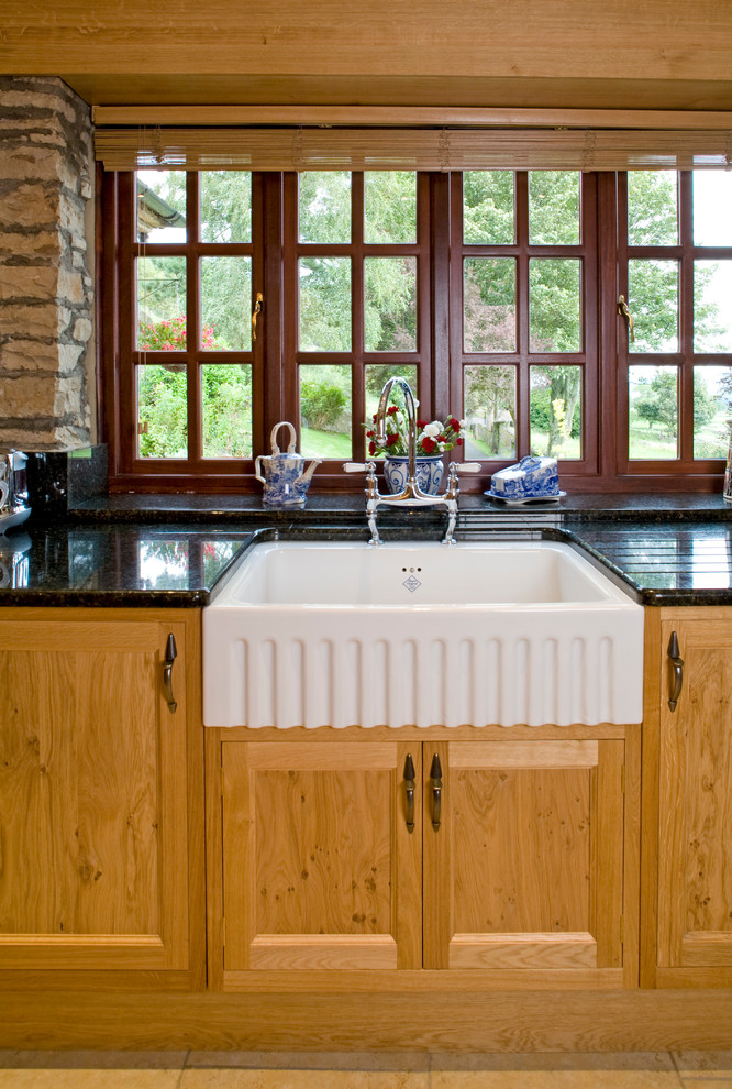 Immagine di una cucina tradizionale di medie dimensioni con lavello stile country, ante in stile shaker, ante in legno scuro, top in granito e elettrodomestici in acciaio inossidabile