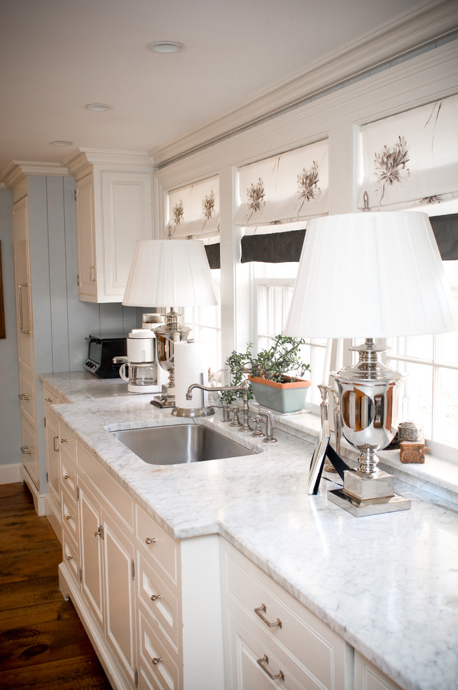 Eat-in kitchen - mid-sized cottage single-wall dark wood floor eat-in kitchen idea in Manchester with a single-bowl sink, marble countertops, white cabinets, stainless steel appliances and raised-panel cabinets