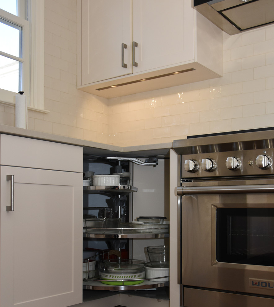 Idéer för att renovera ett mellanstort funkis kök, med en undermonterad diskho, skåp i shakerstil, vita skåp, bänkskiva i kvarts, beige stänkskydd, stänkskydd i glaskakel, rostfria vitvaror, mörkt trägolv och en köksö