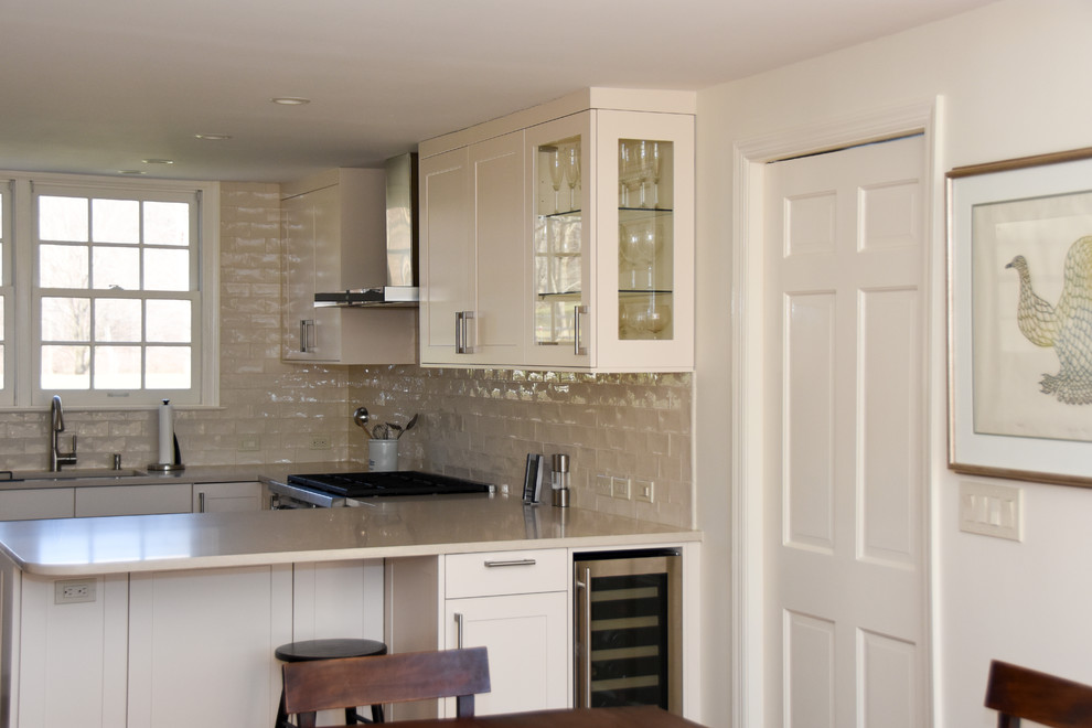 Foto på ett mellanstort funkis kök, med en undermonterad diskho, skåp i shakerstil, vita skåp, bänkskiva i kvarts, beige stänkskydd, stänkskydd i glaskakel, rostfria vitvaror, mörkt trägolv och en köksö