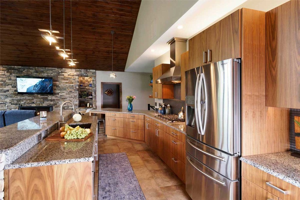 This is an example of a large contemporary l-shaped kitchen/diner in Philadelphia with a submerged sink, flat-panel cabinets, medium wood cabinets, granite worktops, grey splashback, metal splashback, stainless steel appliances, ceramic flooring, an island, beige floors and multicoloured worktops.