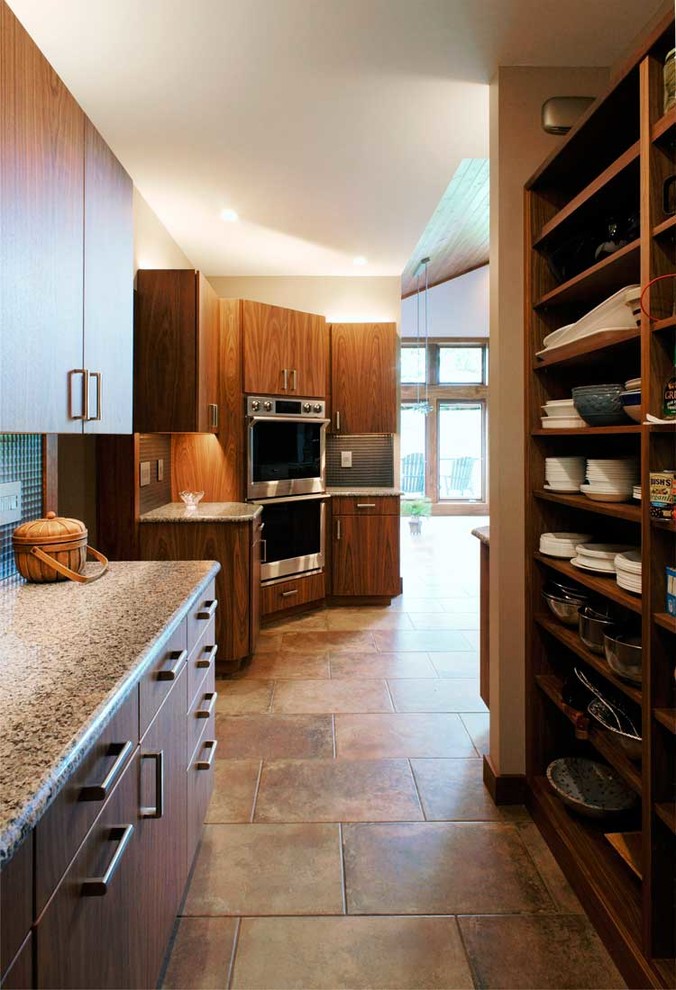 Modern inredning av ett stort flerfärgad flerfärgat kök, med en undermonterad diskho, släta luckor, skåp i mellenmörkt trä, granitbänkskiva, grått stänkskydd, stänkskydd i metallkakel, rostfria vitvaror, klinkergolv i keramik, en köksö och beiget golv