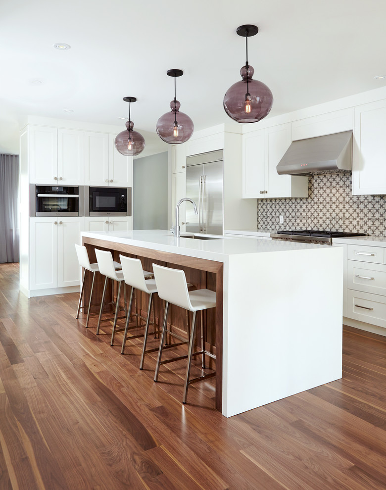 Inspiration for a large transitional l-shaped medium tone wood floor open concept kitchen remodel in Toronto with an undermount sink, shaker cabinets, medium tone wood cabinets, quartz countertops, multicolored backsplash, ceramic backsplash, stainless steel appliances and an island