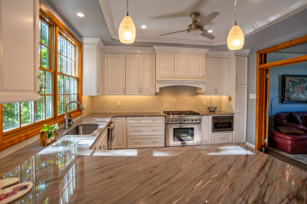 Bild på ett stort vintage brun brunt kök, med en undermonterad diskho, luckor med upphöjd panel, vita skåp, bänkskiva i kvarts, vitt stänkskydd, stänkskydd i glaskakel, rostfria vitvaror, mellanmörkt trägolv, en halv köksö och brunt golv