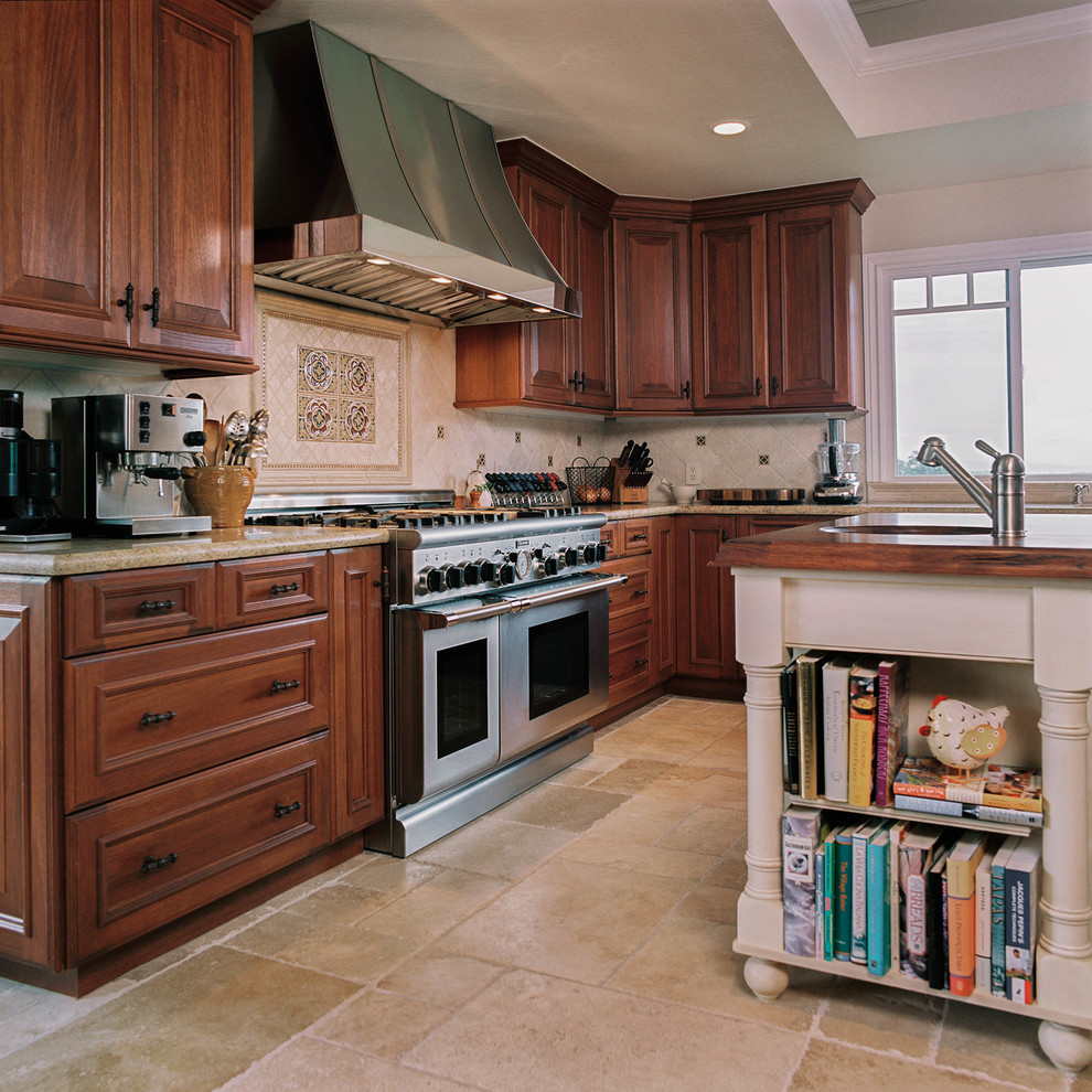 Klassisk inredning av ett stort kök, med en undermonterad diskho, luckor med upphöjd panel, skåp i mörkt trä, granitbänkskiva, beige stänkskydd, stänkskydd i stenkakel, rostfria vitvaror, travertin golv och en köksö