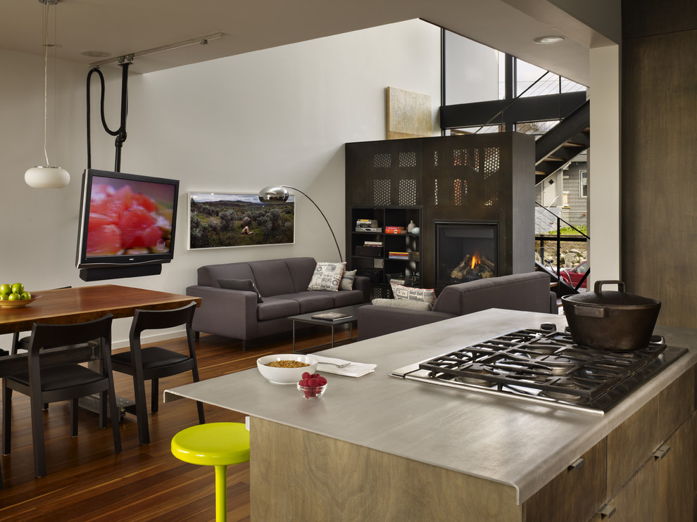Inspiration for a small modern galley medium tone wood floor open concept kitchen remodel in Seattle with an undermount sink, flat-panel cabinets, medium tone wood cabinets, stainless steel countertops, stainless steel appliances and an island