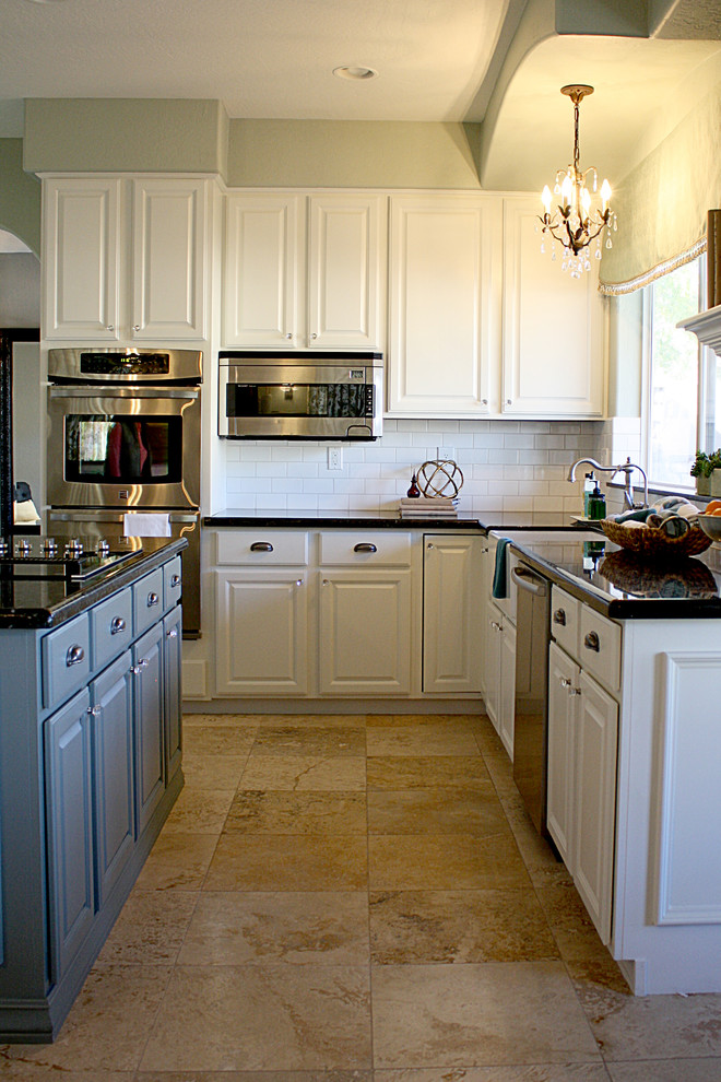 Inredning av ett klassiskt stort kök, med en rustik diskho, luckor med upphöjd panel, gröna skåp, granitbänkskiva, vitt stänkskydd, stänkskydd i tunnelbanekakel, rostfria vitvaror och travertin golv