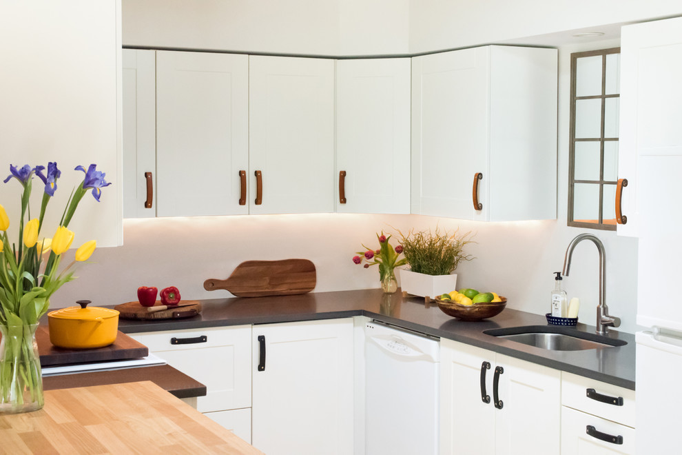 Idéer för att renovera ett mellanstort funkis grå grått kök, med en undermonterad diskho, skåp i shakerstil, vita skåp, granitbänkskiva, vitt stänkskydd, vita vitvaror, bambugolv, en köksö och beiget golv