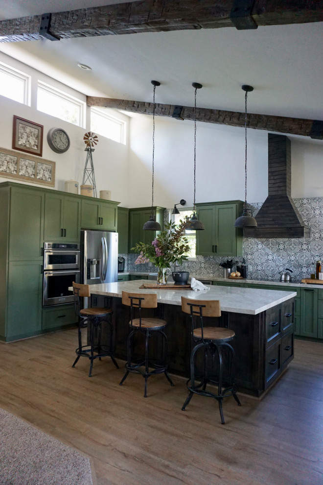 Example of a mid-sized farmhouse vinyl floor and beige floor eat-in kitchen design in Other with a farmhouse sink, shaker cabinets, green cabinets, quartzite countertops, multicolored backsplash, ceramic backsplash, an island, beige countertops and stainless steel appliances