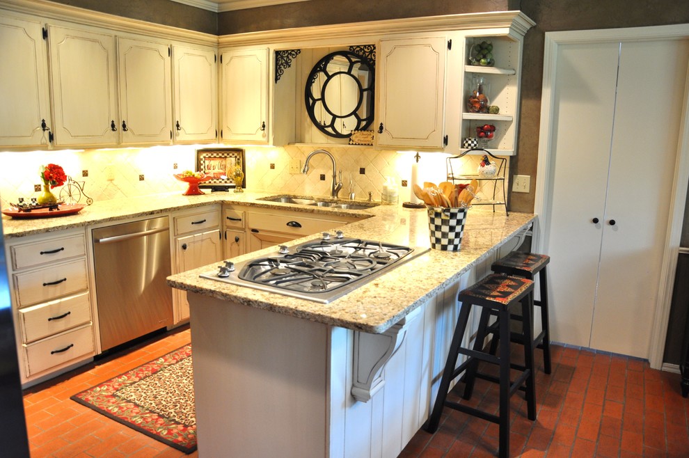 Inredning av ett klassiskt litet kök, med en trippel diskho, beige skåp, granitbänkskiva, beige stänkskydd, stänkskydd i stenkakel, rostfria vitvaror, tegelgolv, luckor med infälld panel och en halv köksö