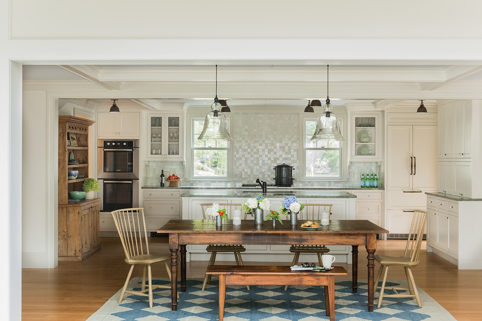 Exempel på ett mellanstort klassiskt kök, med en undermonterad diskho, vita skåp, granitbänkskiva, stänkskydd i mosaik, rostfria vitvaror, ljust trägolv, en köksö, stänkskydd med metallisk yta och beiget golv