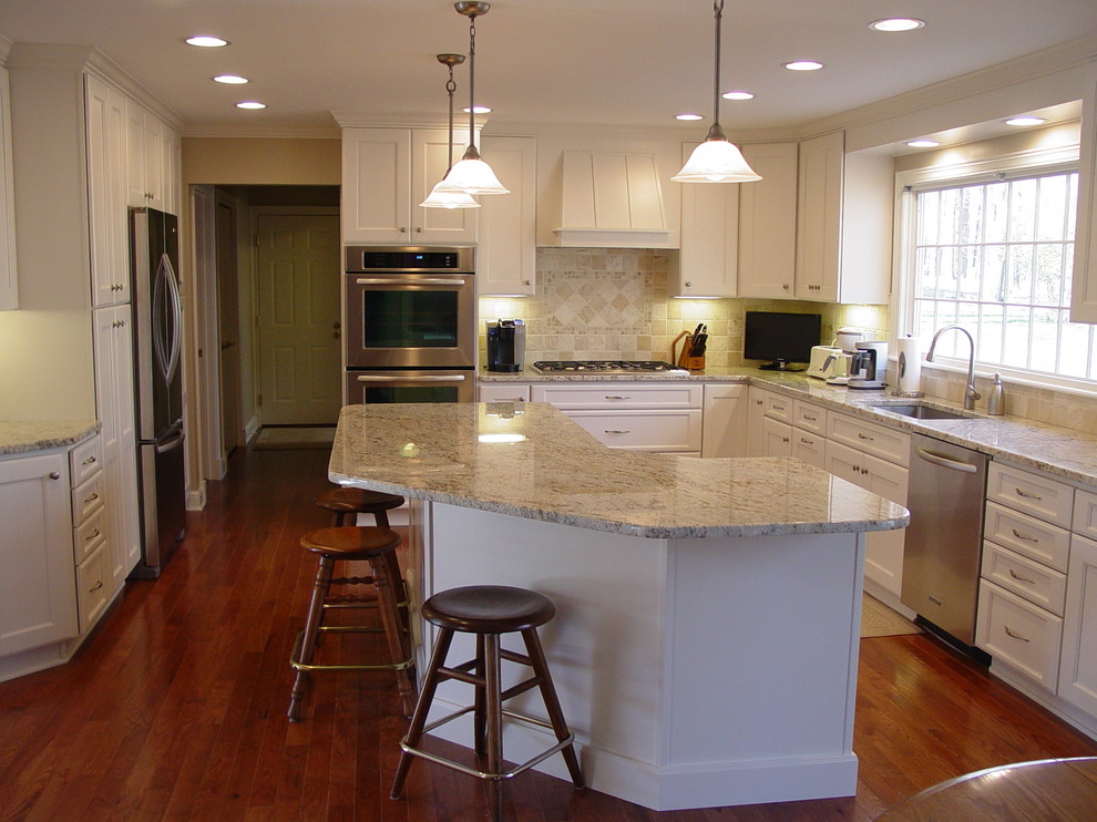 Eat-in kitchen - mid-sized transitional l-shaped dark wood floor and red floor eat-in kitchen idea in Cleveland with an undermount sink, recessed-panel cabinets, white cabinets, granite countertops, beige backsplash, stone tile backsplash, stainless steel appliances and an island