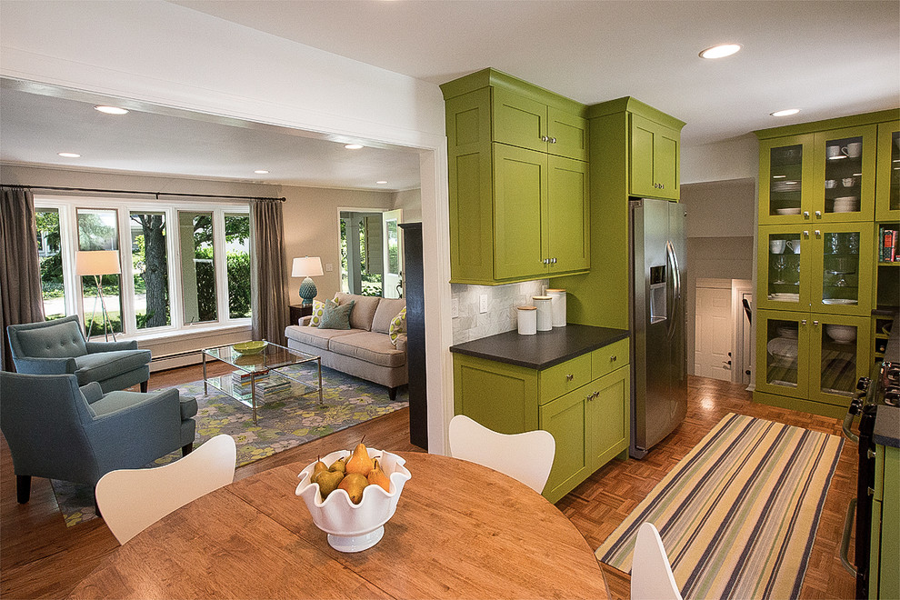 Bild på ett litet 60 tals kök, med en undermonterad diskho, skåp i shakerstil, gröna skåp, laminatbänkskiva, grått stänkskydd, stänkskydd i stenkakel, rostfria vitvaror och mellanmörkt trägolv