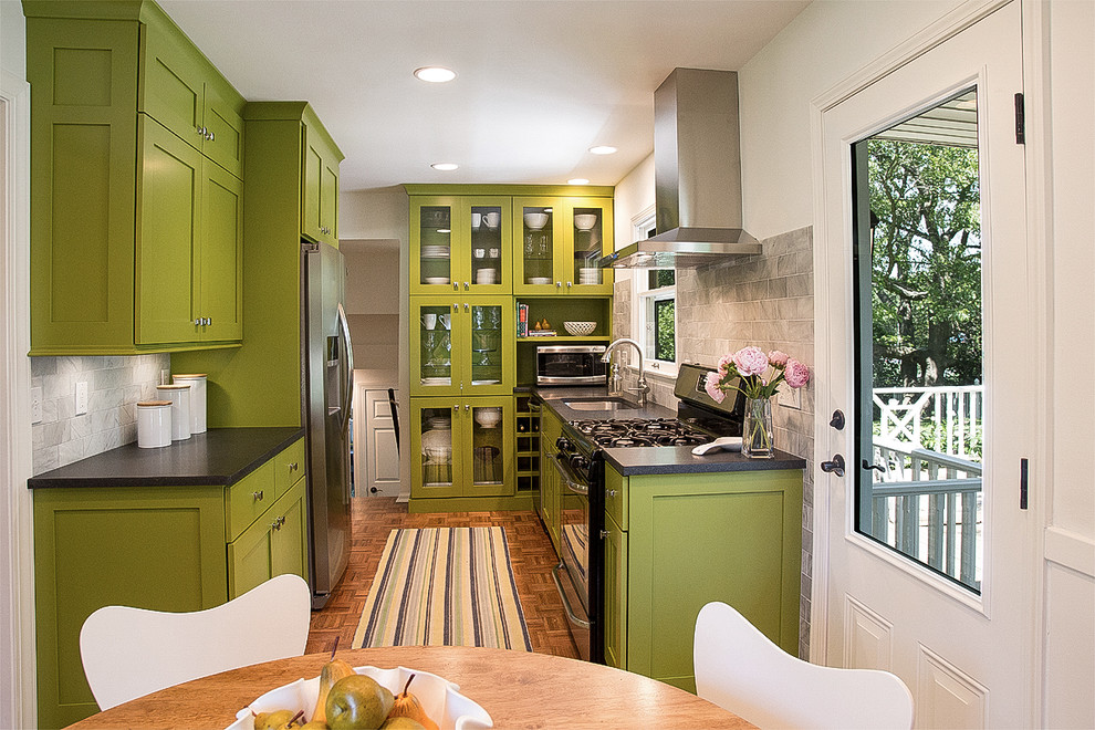 Foto på ett litet retro kök, med en undermonterad diskho, skåp i shakerstil, gröna skåp, laminatbänkskiva, grått stänkskydd, stänkskydd i stenkakel, rostfria vitvaror och mellanmörkt trägolv