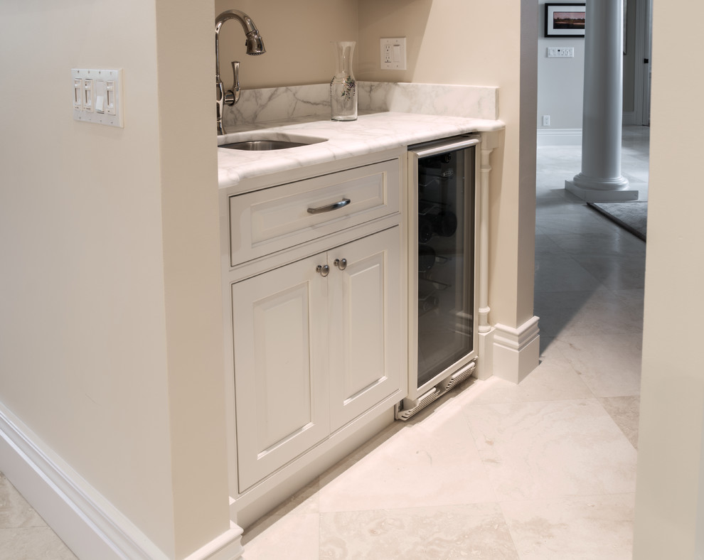 Example of a large transitional u-shaped limestone floor and white floor open concept kitchen design in Orlando with an undermount sink, raised-panel cabinets, white cabinets, marble countertops, gray backsplash, marble backsplash, stainless steel appliances and two islands