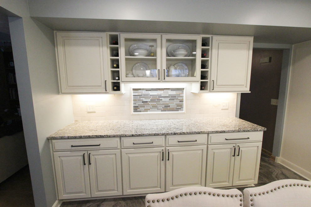 Inspiration for a mid-sized transitional galley vinyl floor and gray floor eat-in kitchen remodel in Cleveland with an undermount sink, raised-panel cabinets, white cabinets, granite countertops, beige backsplash, glass sheet backsplash, stainless steel appliances, an island and beige countertops