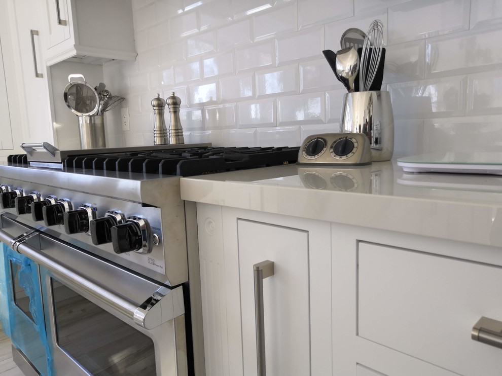 Exempel på ett mellanstort klassiskt vit vitt kök, med en rustik diskho, luckor med infälld panel, vita skåp, bänkskiva i koppar, vitt stänkskydd, stänkskydd i tunnelbanekakel, rostfria vitvaror, klinkergolv i porslin, en köksö och grått golv