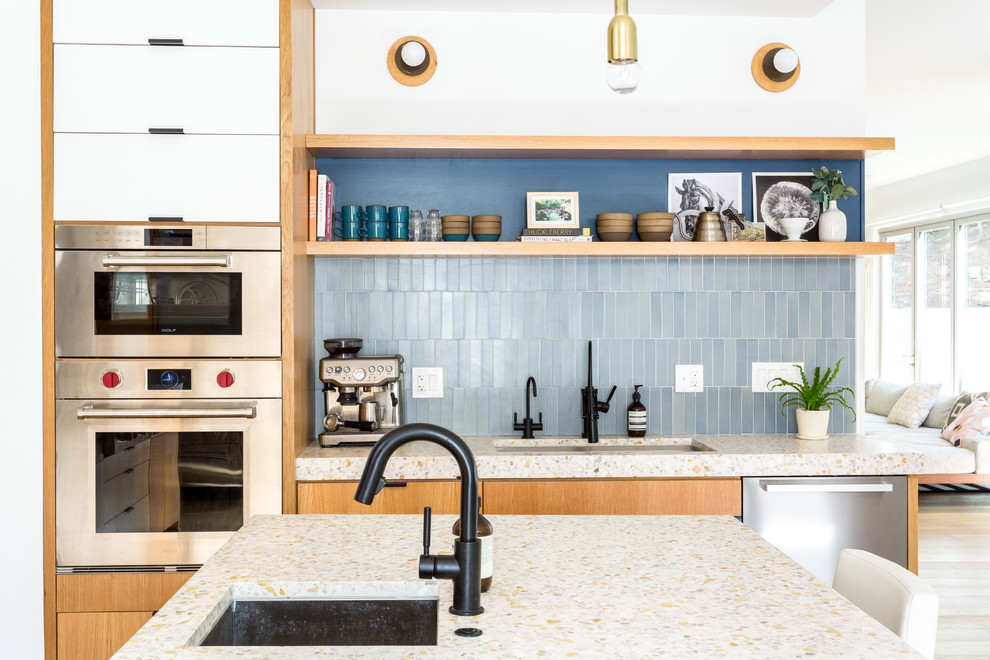 Inspiration for a large 1950s galley light wood floor open concept kitchen remodel in Los Angeles with an undermount sink, flat-panel cabinets, blue cabinets, concrete countertops, blue backsplash, ceramic backsplash, stainless steel appliances and an island
