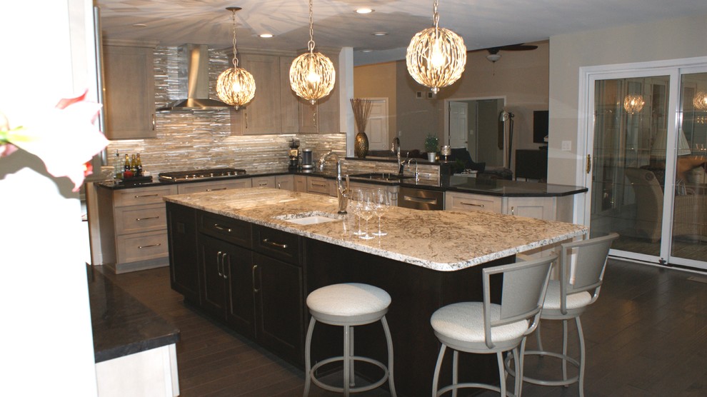Example of a large classic u-shaped dark wood floor and brown floor eat-in kitchen design with an undermount sink, shaker cabinets, gray cabinets, granite countertops, multicolored backsplash, metal backsplash, stainless steel appliances, an island and black countertops
