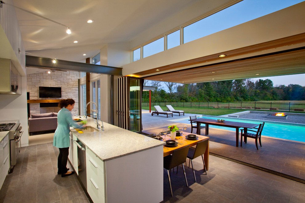 Eat-in kitchen - modern galley eat-in kitchen idea in Cincinnati with an undermount sink, flat-panel cabinets, white cabinets, stainless steel appliances and granite countertops
