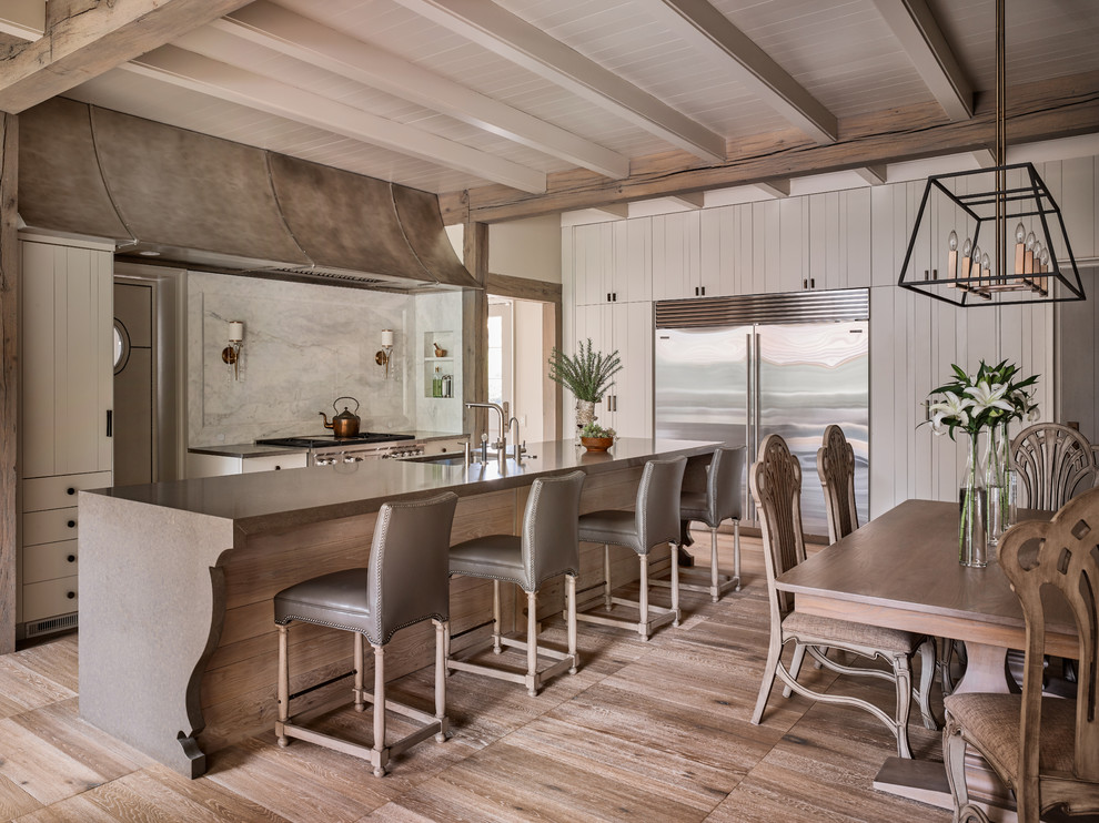 Exempel på ett maritimt brun brunt kök och matrum, med en undermonterad diskho, beige skåp, vitt stänkskydd, stänkskydd i marmor, rostfria vitvaror, mellanmörkt trägolv och en köksö