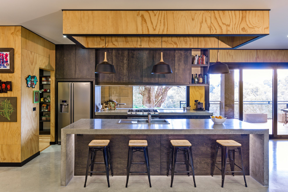 Contemporary kitchen pantry in Melbourne with concrete worktops, glass sheet splashback, stainless steel appliances, concrete flooring and an island.