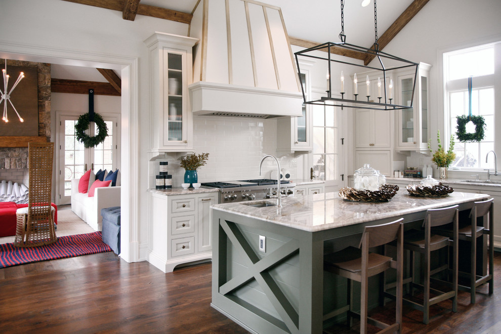 Design ideas for a farmhouse l-shaped kitchen in Atlanta with recessed-panel cabinets, white cabinets, white splashback, metro tiled splashback, stainless steel appliances, dark hardwood flooring and an island.