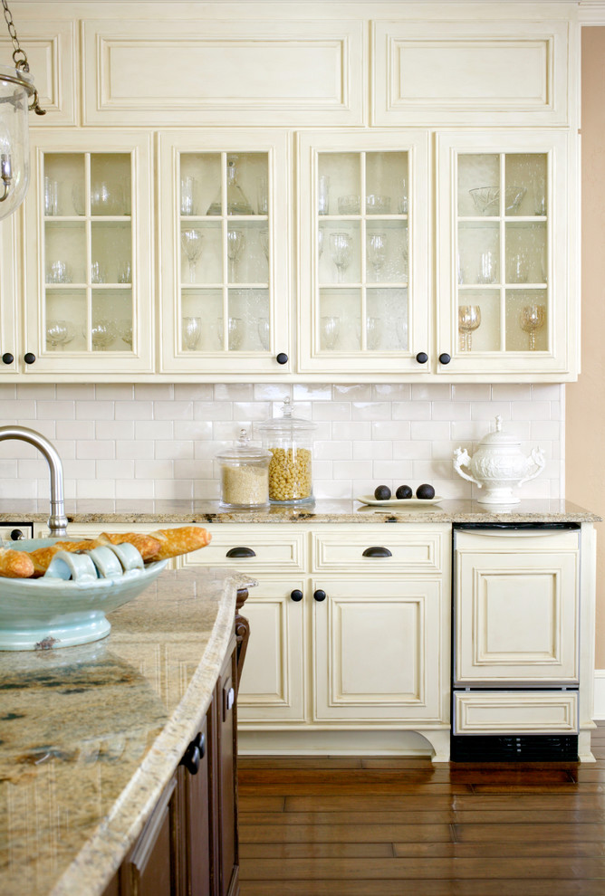 Пример оригинального дизайна: кухня в классическом стиле с стеклянными фасадами, белыми фасадами, белым фартуком и фартуком из плитки кабанчик
