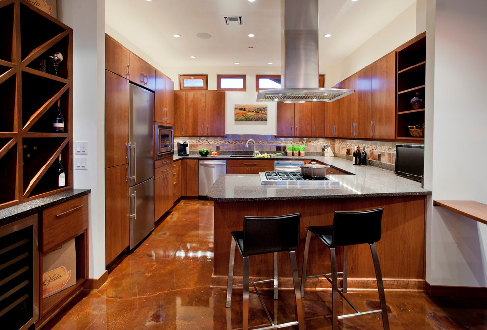 Immagine di una cucina ad U design con top in superficie solida, elettrodomestici in acciaio inossidabile, ante lisce, ante in legno scuro e paraspruzzi marrone