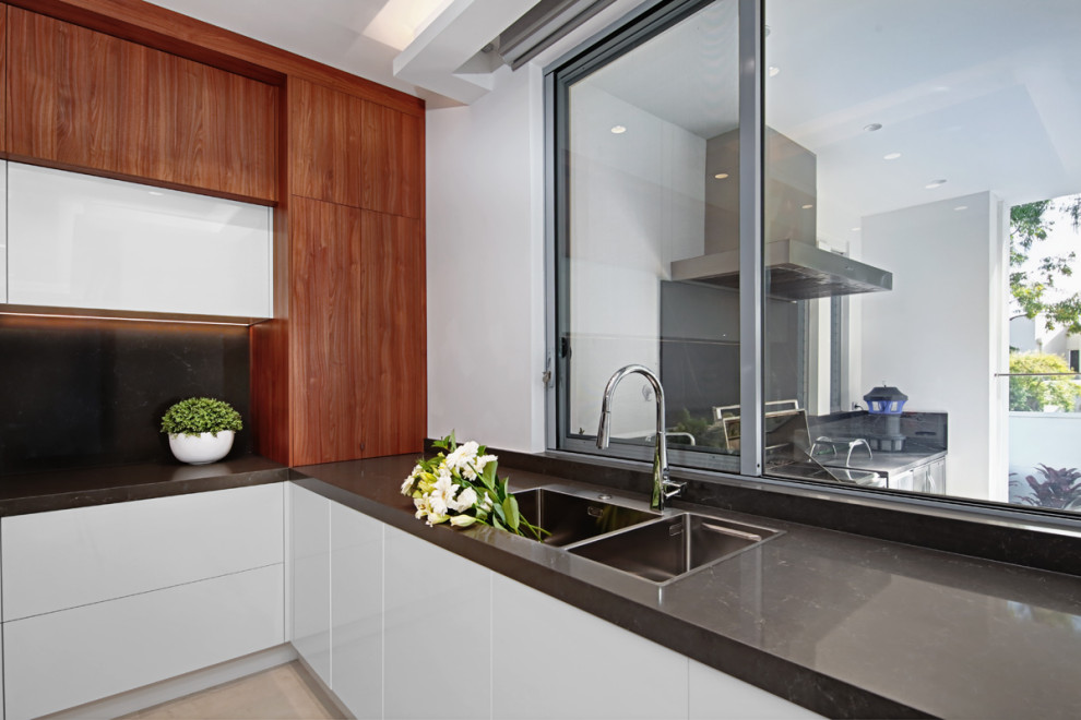 Photo of a medium sized modern u-shaped open plan kitchen in Sydney with a double-bowl sink, recessed-panel cabinets, dark wood cabinets, marble worktops, black splashback, marble splashback, black appliances, ceramic flooring, an island, beige floors, black worktops and a coffered ceiling.