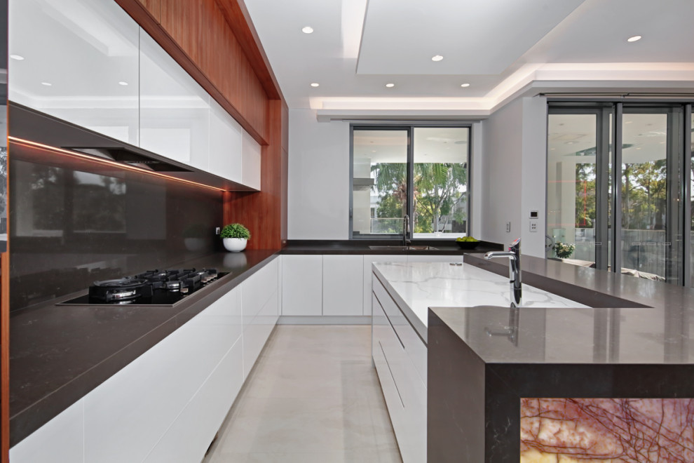 Mid-sized minimalist u-shaped ceramic tile, beige floor and coffered ceiling open concept kitchen photo in Sydney with a double-bowl sink, recessed-panel cabinets, dark wood cabinets, marble countertops, black backsplash, marble backsplash, black appliances, an island and black countertops