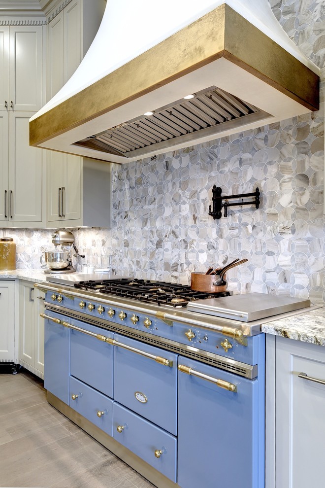 Inspiration for a huge mediterranean u-shaped light wood floor and gray floor open concept kitchen remodel in Austin with an undermount sink, shaker cabinets, beige cabinets, granite countertops, blue backsplash, marble backsplash, paneled appliances, two islands and gray countertops