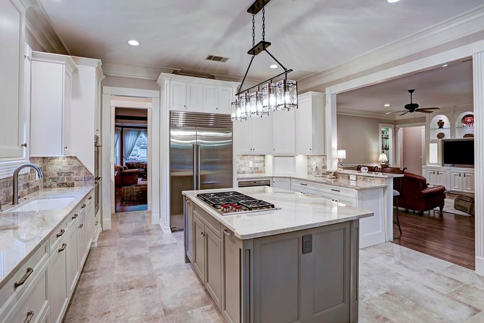 Inspiration for a mid-sized craftsman l-shaped porcelain tile and gray floor eat-in kitchen remodel in Houston with an undermount sink, shaker cabinets, white cabinets, quartzite countertops, gray backsplash, travertine backsplash, stainless steel appliances, an island and beige countertops