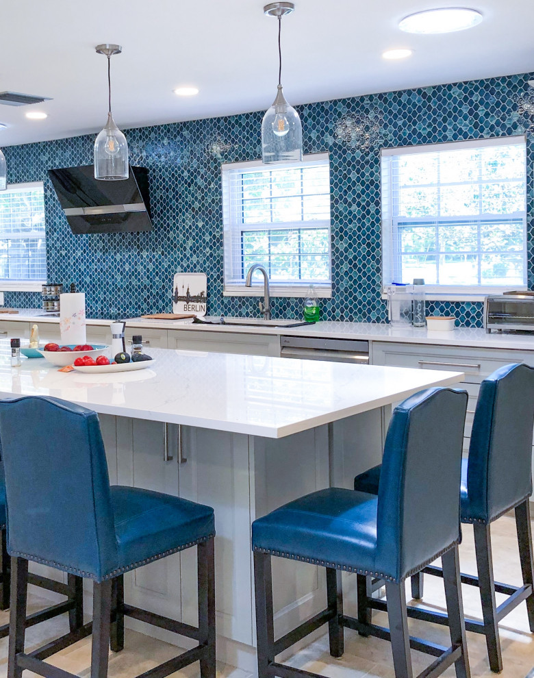 タンパにあるトランジショナルスタイルのおしゃれなキッチン (アンダーカウンターシンク、落し込みパネル扉のキャビネット、白いキャビネット、珪岩カウンター、青いキッチンパネル、モザイクタイルのキッチンパネル、シルバーの調理設備、ベージュの床、白いキッチンカウンター) の写真