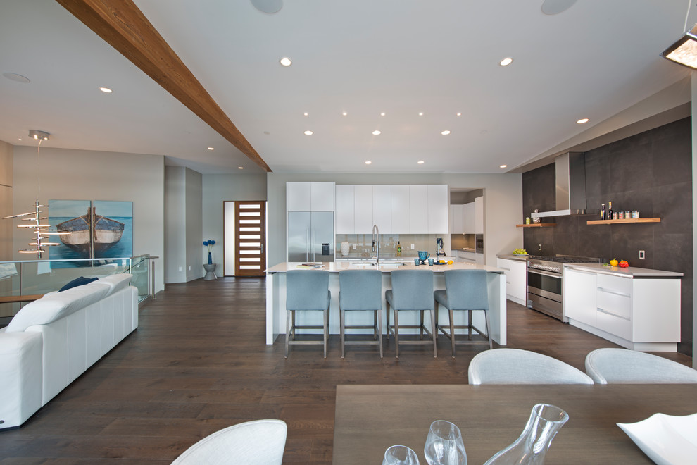 Large contemporary kitchen/diner in Other with a submerged sink, flat-panel cabinets, engineered stone countertops, grey splashback, glass sheet splashback, stainless steel appliances, an island and white worktops.