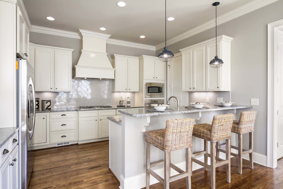 Inspiration for an eclectic l-shaped eat-in kitchen remodel in Nashville with an undermount sink, beaded inset cabinets, white cabinets, granite countertops, beige backsplash, ceramic backsplash and stainless steel appliances