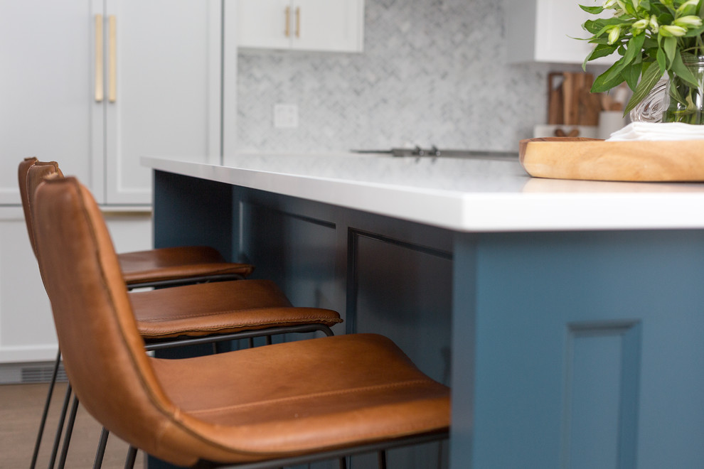 Foto på ett stort funkis kök, med en rustik diskho, skåp i shakerstil, blå skåp, bänkskiva i kvarts, vitt stänkskydd, stänkskydd i marmor, integrerade vitvaror, mellanmörkt trägolv, flera köksöar och brunt golv