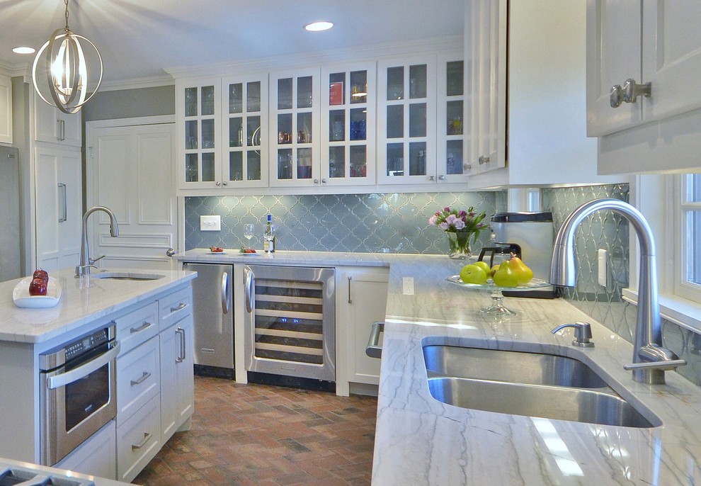 Foto di una cucina classica di medie dimensioni con lavello sottopiano, ante in stile shaker, ante bianche, top in quarzite, paraspruzzi blu, paraspruzzi con piastrelle di vetro, elettrodomestici in acciaio inossidabile e pavimento in mattoni