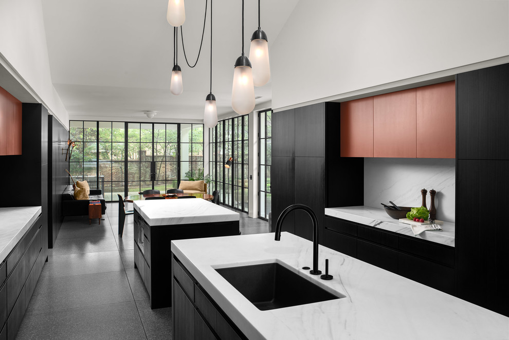 Идея дизайна: кухня-гостиная в стиле модернизм с врезной мойкой, плоскими фасадами, черными фасадами, мраморной столешницей, фартуком из мрамора, техникой под мебельный фасад, полом из терраццо, двумя и более островами, серым полом и белой столешницей