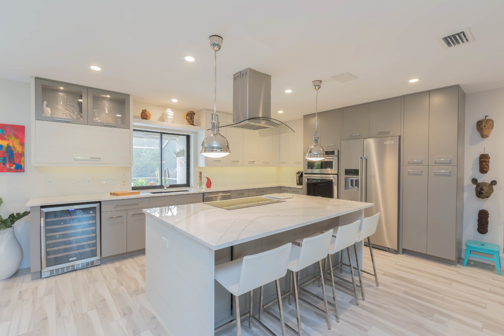Inspiration for a large modern l-shaped porcelain tile and gray floor open concept kitchen remodel in Other with an undermount sink, flat-panel cabinets, gray cabinets, quartz countertops, ceramic backsplash, stainless steel appliances and an island