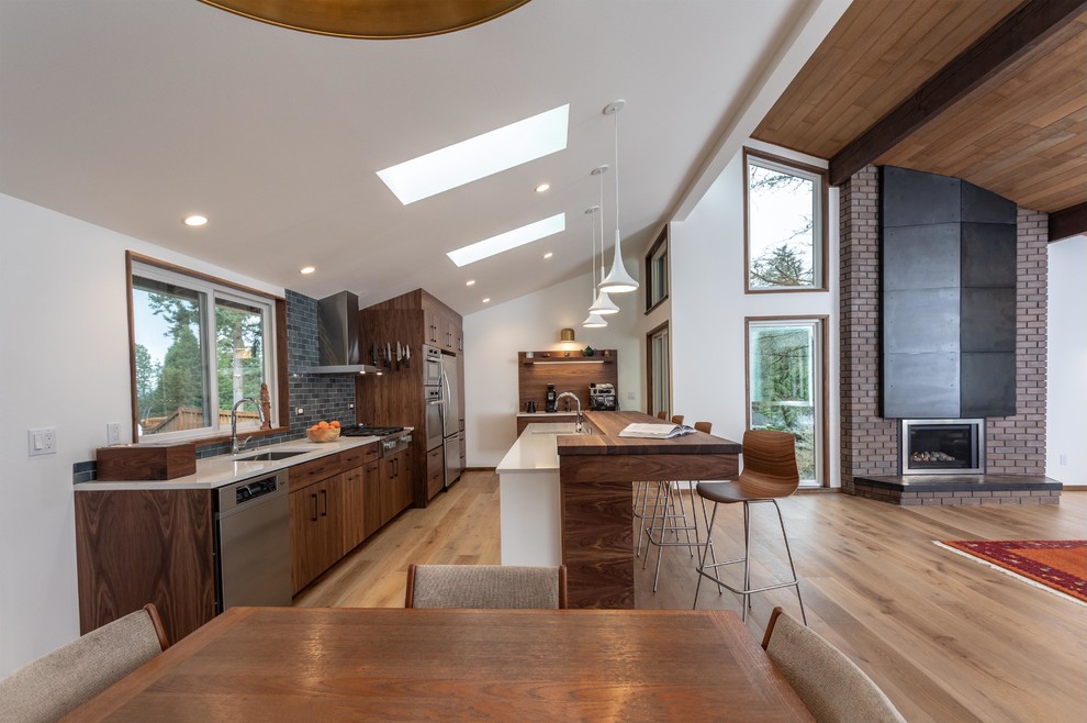 Inspiration for a large contemporary open plan kitchen in Seattle with flat-panel cabinets, dark wood cabinets, engineered stone countertops, an island and white worktops.