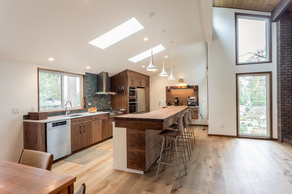 Inspiration for a large contemporary open plan kitchen in Seattle with flat-panel cabinets, dark wood cabinets, engineered stone countertops, an island and white worktops.