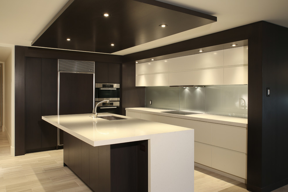 Immagine di una piccola cucina minimalista con lavello sottopiano, ante lisce, ante bianche, paraspruzzi con lastra di vetro, elettrodomestici in acciaio inossidabile e parquet chiaro