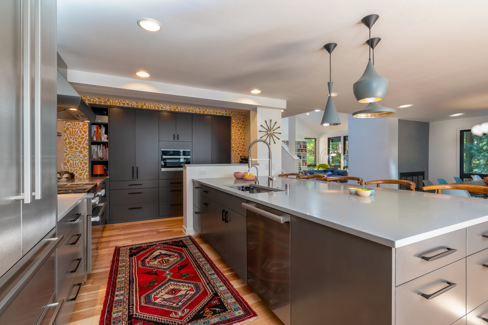 Moderne Küche in L-Form mit Unterbauwaschbecken, flächenbündigen Schrankfronten, grauen Schränken, braunem Holzboden, Kücheninsel, braunem Boden, weißer Arbeitsplatte und Tapete in Seattle