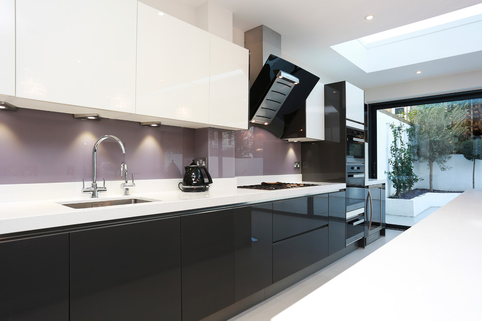 Geräumige Moderne Wohnküche mit Unterbauwaschbecken, grauen Schränken, Glasrückwand, Küchengeräten aus Edelstahl, Keramikboden und Kücheninsel in London