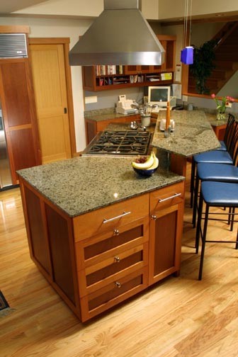 Example of a large arts and crafts medium tone wood floor eat-in kitchen design in Seattle with an undermount sink, shaker cabinets, dark wood cabinets, granite countertops, stone slab backsplash, stainless steel appliances and an island